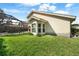 Back exterior with a large grassy lawn, plants and a bay window to the house at 5290 White Sand Ne Cir, St Petersburg, FL 33703