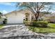 Charming one-story home featuring a manicured front yard, mature landscaping, and a spacious driveway at 5290 White Sand Ne Cir, St Petersburg, FL 33703