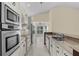 Modern kitchen with white cabinets, granite countertops, stainless steel appliances, and natural light from shuttered windows at 5290 White Sand Ne Cir, St Petersburg, FL 33703