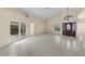 Spacious living room with vaulted ceilings, neutral paint, tile floors, and a decorative front door at 5290 White Sand Ne Cir, St Petersburg, FL 33703