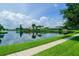 Scenic waterfront homes located on a large pond with lush green walking path and beautiful blue skies at 5290 White Sand Ne Cir, St Petersburg, FL 33703