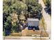 An aerial view of a home with a gray roof, framed by trees, adjacent to a quiet road at 5401 E 14Th Ave, Tampa, FL 33619