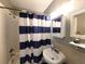 Bathroom with a shower with blue and white curtains and a pedestal sink at 5401 E 14Th Ave, Tampa, FL 33619
