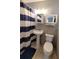Bathroom with a toilet, a pedestal sink, and a shower with blue and white curtains at 5401 E 14Th Ave, Tampa, FL 33619
