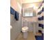 Cozy bathroom with white tiled walls, a pedestal sink, toilet, and a window offering natural light at 5401 E 14Th Ave, Tampa, FL 33619