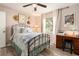 Charming bedroom featuring a decorative iron bed frame, complemented by a ceiling fan and light-filled window at 626 Marphil Loop, Brandon, FL 33511