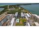 This aerial shot shows a community with a pool, parking, a nearby road, and lots of green landscaping at 7 Island Park Pl # 204, Dunedin, FL 34698