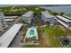 Aerial view showcasing the community's layout, including condos, pool, covered parking, and lush landscaping at 7 Island Park Pl # 204, Dunedin, FL 34698