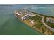 Stunning aerial view of a condominium complex nestled on a lush peninsula, surrounded by sparkling blue waters at 7 Island Park Pl # 204, Dunedin, FL 34698