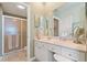 Well-lit bathroom featuring a walk-in shower and vanity with makeup area at 7 Island Park Pl # 204, Dunedin, FL 34698