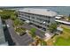 View of the building exterior and parking area, with palm trees and water views from the residential levels at 7 Island Park Pl # 204, Dunedin, FL 34698
