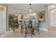 Elegant dining area with a mirrored wall, decorative lighting, and seating for four at 7 Island Park Pl # 204, Dunedin, FL 34698