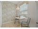 Cozy dining area featuring decorative wallpaper, pendant lighting, and a view to the exterior at 7 Island Park Pl # 204, Dunedin, FL 34698