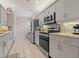 Well-lit kitchen featuring stainless steel appliances, granite countertops and light gray cabinets at 7 Island Park Pl # 204, Dunedin, FL 34698