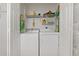 This practical laundry area has a stacked washer and dryer, plus storage shelves for supplies and cleaning essentials at 7 Island Park Pl # 204, Dunedin, FL 34698