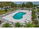 Aerial view of fenced pool area with lounge chairs surrounded by lush tropical landscaping at 7 Island Park Pl # 204, Dunedin, FL 34698