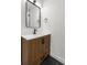 Modern bathroom vanity with wood cabinets, square framed mirror, and matte black fixtures at 7050 Jenner Ave, New Port Richey, FL 34655