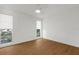 Bright bedroom featuring wood floors, white walls, and a window with a view at 7050 Jenner Ave, New Port Richey, FL 34655