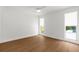 Bright bedroom featuring wood floors, white walls, and a window with a view at 7050 Jenner Ave, New Port Richey, FL 34655
