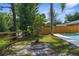 A fire pit sits by the pool overlooking a fenced yard at 7050 Jenner Ave, New Port Richey, FL 34655