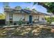 Charming single-story home featuring a blue door, inviting front entrance, and well-maintained landscaping at 7050 Jenner Ave, New Port Richey, FL 34655