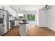 Modern kitchen with stainless steel appliances, island, bright white cabinets, and pool view at 7050 Jenner Ave, New Port Richey, FL 34655