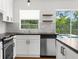Bright kitchen with white cabinets, stainless steel appliances, and a view to the outside pool at 7050 Jenner Ave, New Port Richey, FL 34655