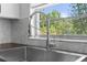 Close up shot of the modern sink and pull down faucet in the kitchen with a great backyard view at 7050 Jenner Ave, New Port Richey, FL 34655