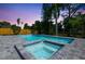 Backyard features a sparkling pool and jacuzzi, surrounded by lush landscaping and a wooden fence at 7050 Jenner Ave, New Port Richey, FL 34655