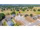Aerial view of the house within the community showcasing the golf course and surrounding mature trees at 7061 Lamium Ct, Brooksville, FL 34602