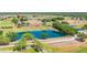 Scenic aerial view of a community lake, pool and clubhouse surrounded by lush greenery and a golf course at 7061 Lamium Ct, Brooksville, FL 34602
