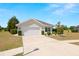 Charming single-story home with a well-manicured lawn, mature trees, and an attached two-car garage at 7061 Lamium Ct, Brooksville, FL 34602