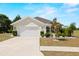 Charming single-story home with a well-manicured lawn, mature trees, and an attached two-car garage at 7061 Lamium Ct, Brooksville, FL 34602