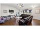 Inviting living room features vaulted ceilings, a ceiling fan, wood floors, and a comfortable leather sofa at 7061 Lamium Ct, Brooksville, FL 34602