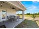 View of the covered patio with outdoor seating, a ceiling fan and outdoor lights overlooking the golf course at 7061 Lamium Ct, Brooksville, FL 34602