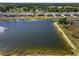 Scenic aerial view of homes along a tranquil lakefront with lush greenery and blue skies at 718 Tidal Rock Ave, Ruskin, FL 33570