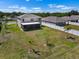 Aerial view of a backyard with a screened-in patio, white fence and young palm trees at 718 Tidal Rock Ave, Ruskin, FL 33570