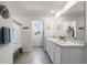 Bright bathroom featuring a shower, gray tile flooring, and double granite vanity at 718 Tidal Rock Ave, Ruskin, FL 33570