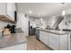 Open kitchen with white cabinets, stainless appliances, granite counters, and wood floors at 718 Tidal Rock Ave, Ruskin, FL 33570