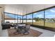 Relaxing screened lanai with seating area and dining table overlooking yard and pond at 718 Tidal Rock Ave, Ruskin, FL 33570