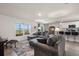 Open-concept living area with modern gray sofa, bar seating, and water view at 718 Tidal Rock Ave, Ruskin, FL 33570