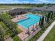 Aerial view of a stunning community pool with lounge chairs, umbrellas, and lush landscaping at 718 Tidal Rock Ave, Ruskin, FL 33570
