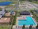 Aerial shot showcasing a sparkling blue swimming pool, playground, and recreation area in a neighborhood at 718 Tidal Rock Ave, Ruskin, FL 33570