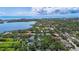 Aerial view of the houses in a lush green community that leads to a pond with ocean in the background at 7314 Hunt Club Ln, Seminole, FL 33776