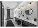 Stunning bathroom featuring a unique stone accent wall, dual sinks and decorative light fixtures at 7314 Hunt Club Ln, Seminole, FL 33776