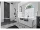 Beautiful bathroom featuring a soaking tub, stone accent wall and patterned tile flooring at 7314 Hunt Club Ln, Seminole, FL 33776
