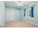 Bright bedroom with neutral carpeting, a closet, and blue curtains framing the window at 7314 Hunt Club Ln, Seminole, FL 33776