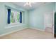 Bright bedroom with neutral carpeting, a ceiling fan, and a window with blue curtains at 7314 Hunt Club Ln, Seminole, FL 33776