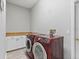 Laundry room with modern red washer and dryer units, and a white storage cabinet at 7314 Hunt Club Ln, Seminole, FL 33776