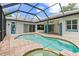 A backyard in-ground pool and spa surrounded by brick pavers is inside a screened enclosure at 7314 Hunt Club Ln, Seminole, FL 33776